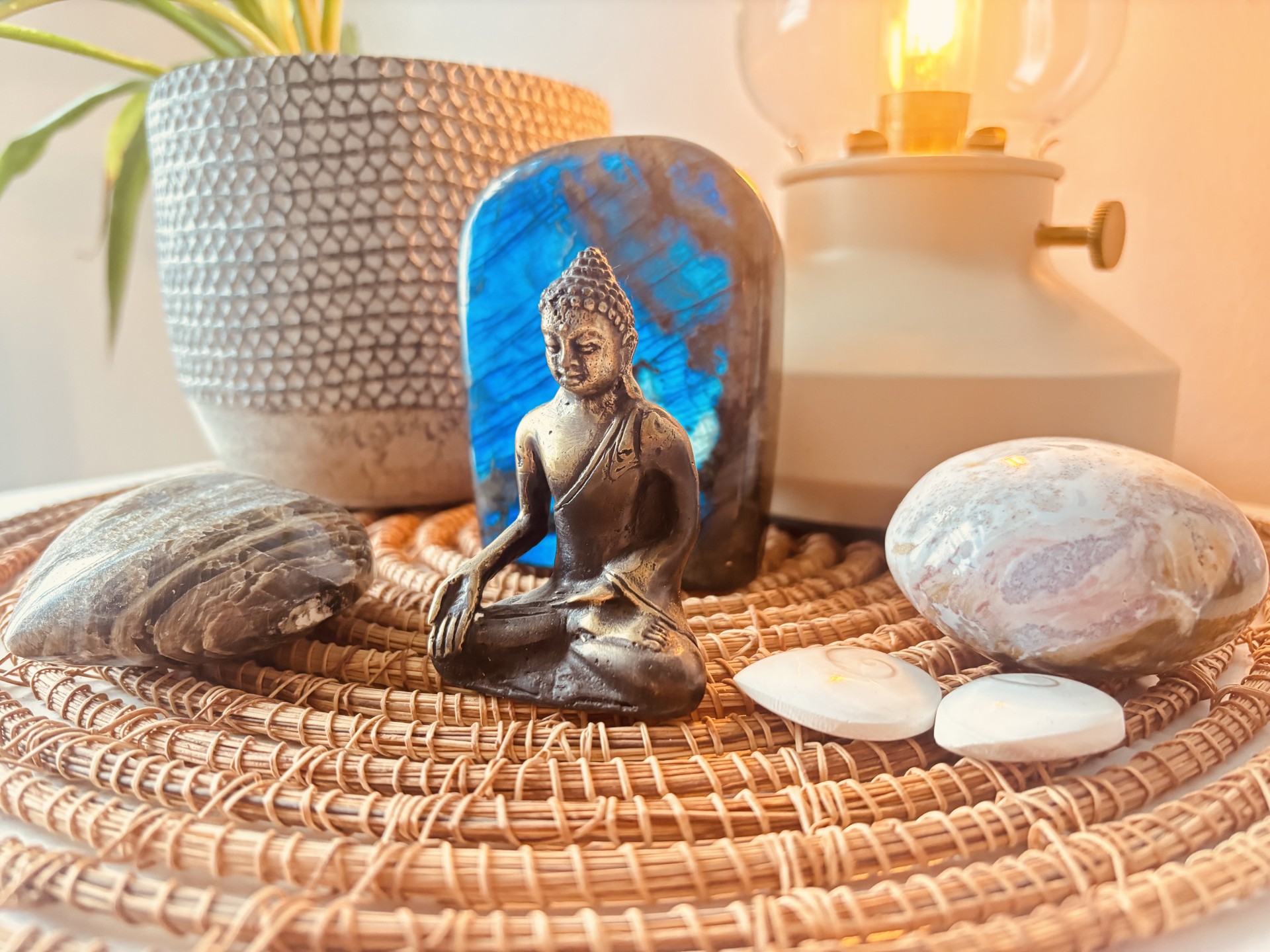Statuette de bouddha en métal, placée devant une labradorite bleue
