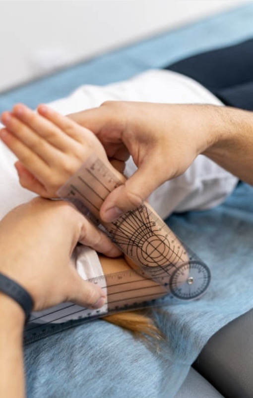 Le kinésiologue mesure l'amplitude de la flexion du coude droit d'un enfant