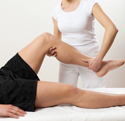 Une kinésiologue manipule la jambe gauche d'un client dans le cadre du Touch For Health